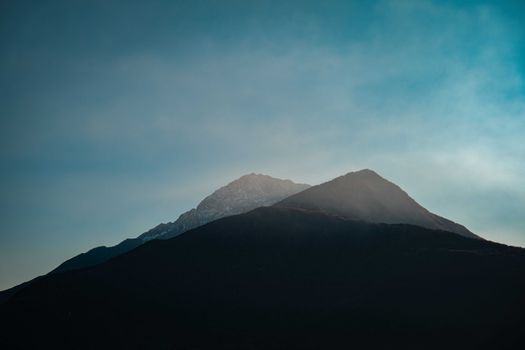 A breathtaking view of misty mountain peaks against a clear sky, capturing nature's beauty.