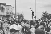 Monochrome scene of a bustling street protest with diverse participants.