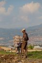 Man in Brown Jacket Carrying Brown Wooden Basket