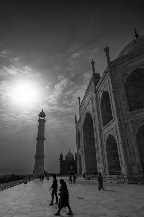 A Grayscale Photo of People Walking in Front of Taj Mahal