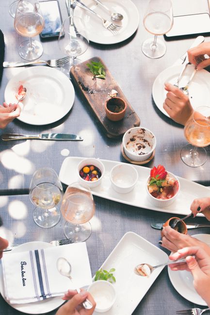 Overhead view of a group dining with shared dishes in an elegant restaurant setting.
