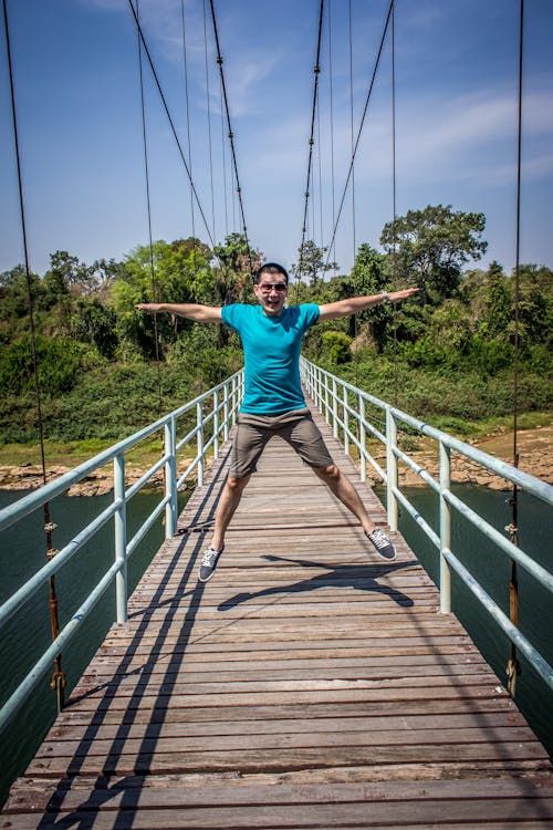 бесплатная Человек прыгает на мосту Стоковое фото