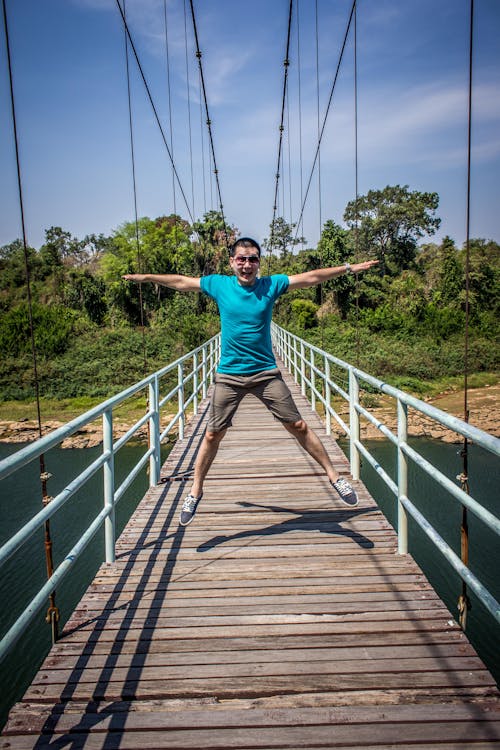 Free Man Jumping On Bridge Stock Photo