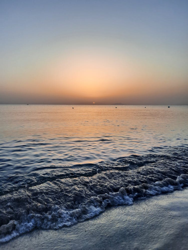 Waves Crashing On The Shore During Sunset