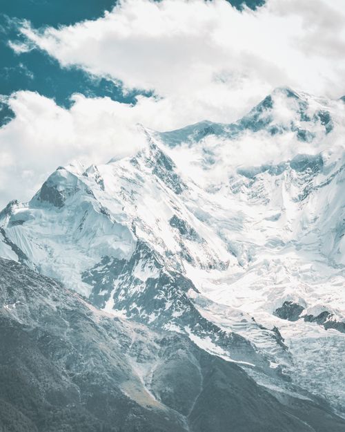 Free A breathtaking view of a snow-covered mountain peak under a cloudy sky, showcasing nature's grandeur. Stock Photo