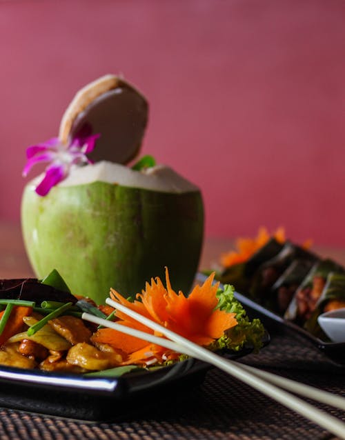  A Plate of Delicious Food Beside Coconut Fruit 