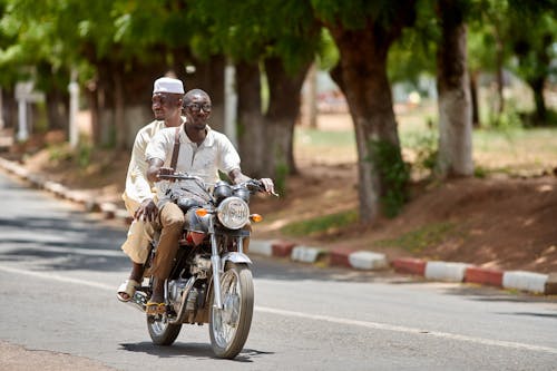 Men Riding a Motorcycle in Tandem