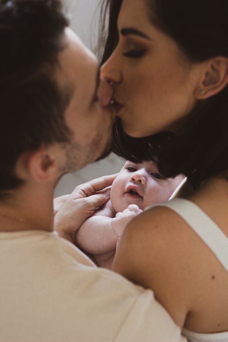 Couple Kissing With Baby