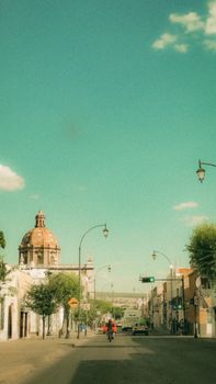 Explore a sunny Mexican street with classic architecture and vibrant atmosphere, ideal for travel imagery.
