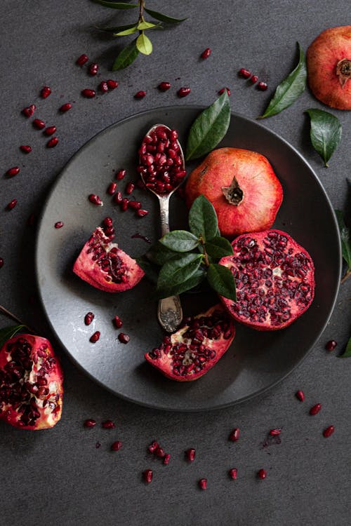 Top View of Fresh Pomegranates on Black Plate