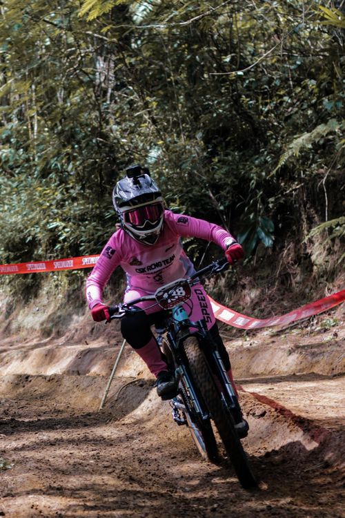Free Intense mountain biking action on a forest dirt trail with a focused biker wearing safety gear. Stock Photo