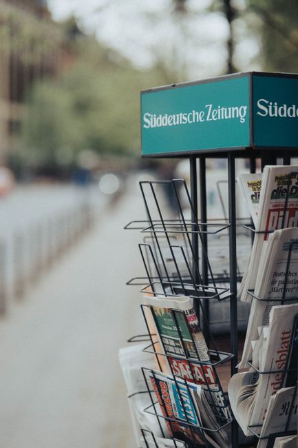 Close-up of a newspaper rack featuring Süddeutsche Zeitung on a city street.