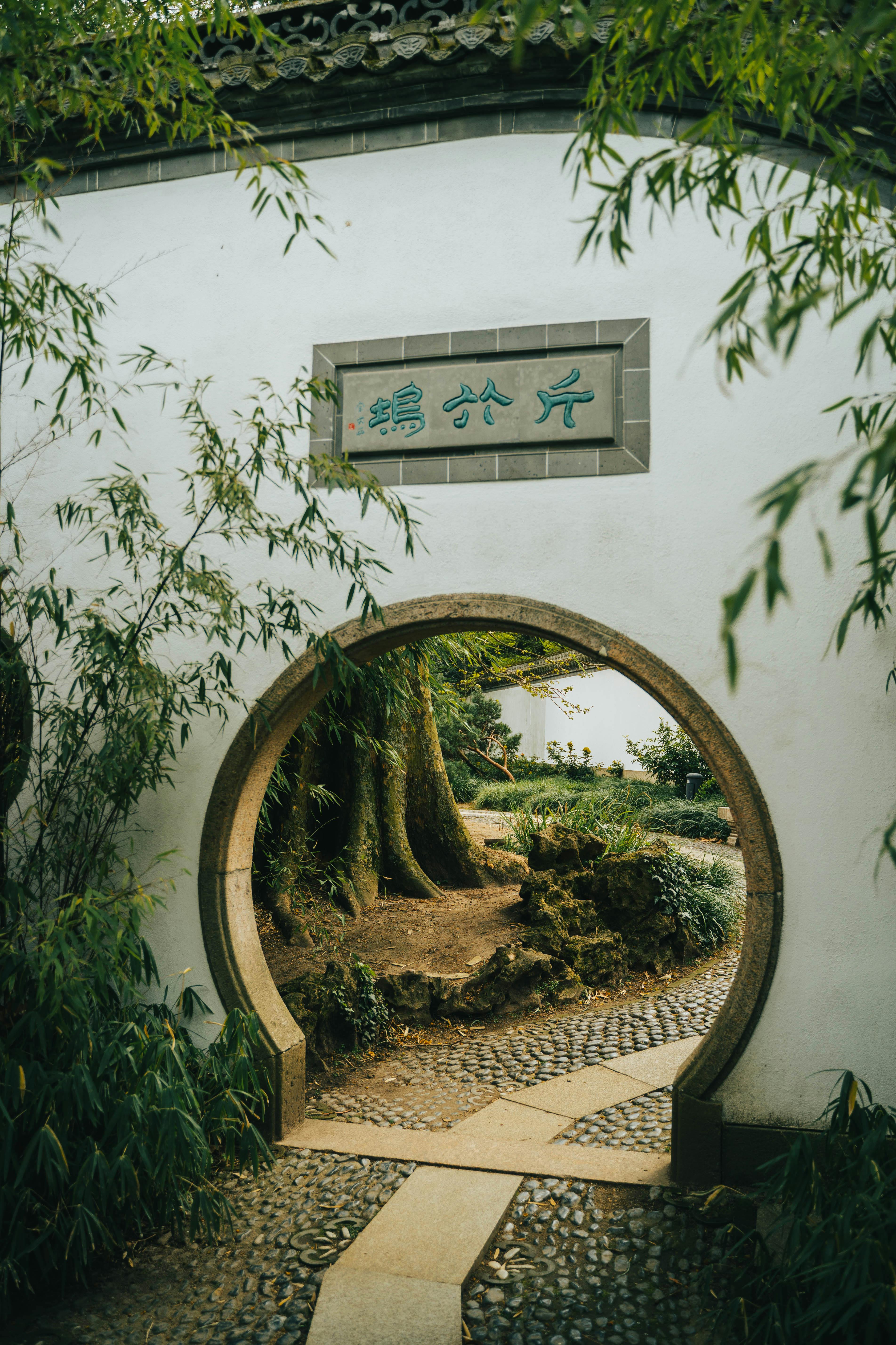 Explore tranquility in a traditional Chinese garden featuring a classic stone moon gate.