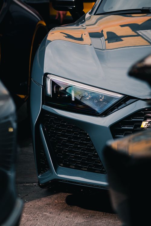 Free Detailed shot of the front end of a sleek luxury sports car under natural lighting. Stock Photo