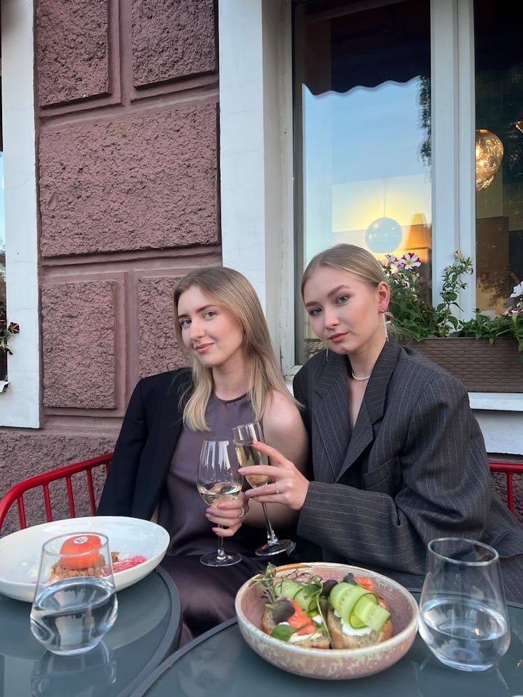 Girls Drinking Wine And Eating In Cafe