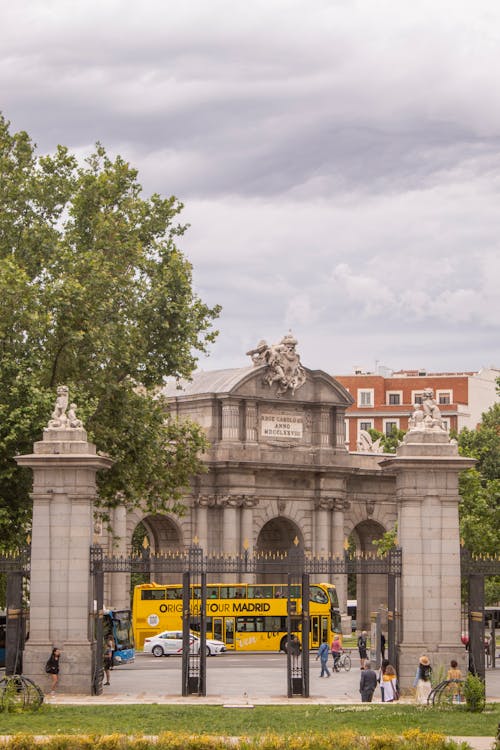 A Moving Yellow Bus Outside the Metal Gate