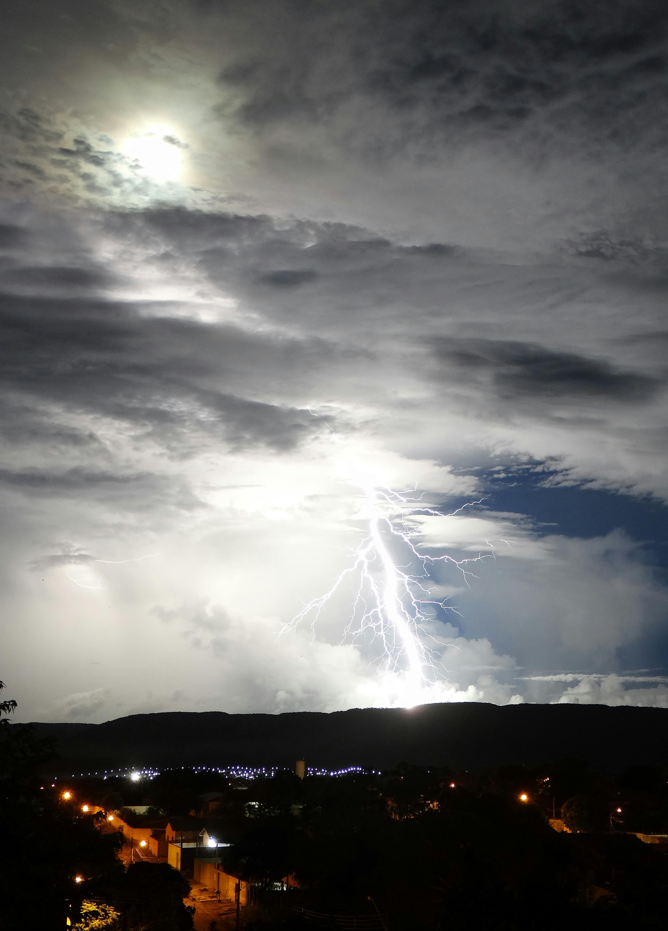Stunning lightning bolt illuminating the night sky above a Brazilian cityscape.
