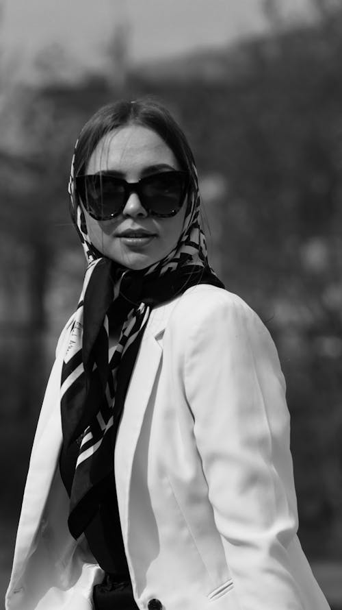 A Woman Wearing Headscarf and Sunglasses while Looking Afar