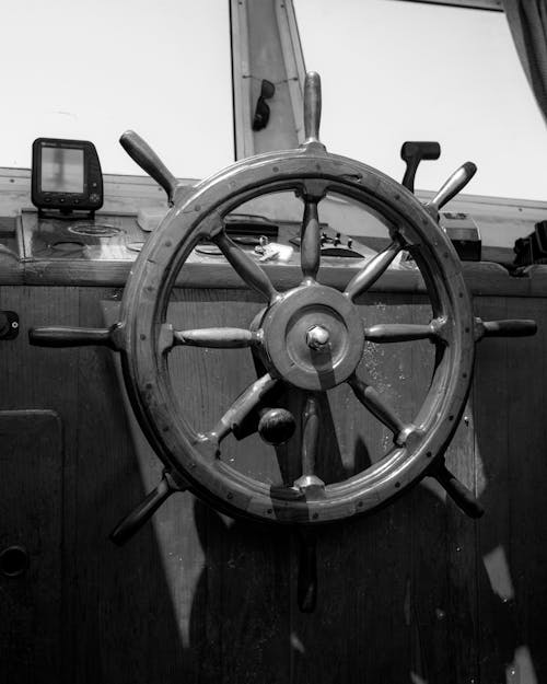 Grayscale Photo of a Wooden Boat Steering Wheel
