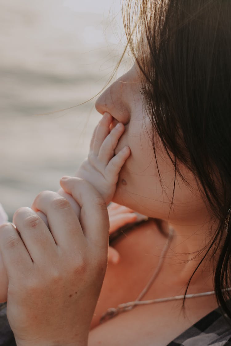 Woman Kissing Baby Hand