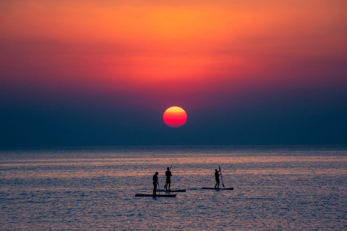 Paddleboarders at sunset