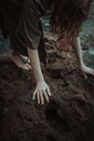 Woman in Black Dress Standing on Brown Rock