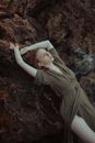 Woman in Brown Long Sleeve Shirt Lying on Brown Rock