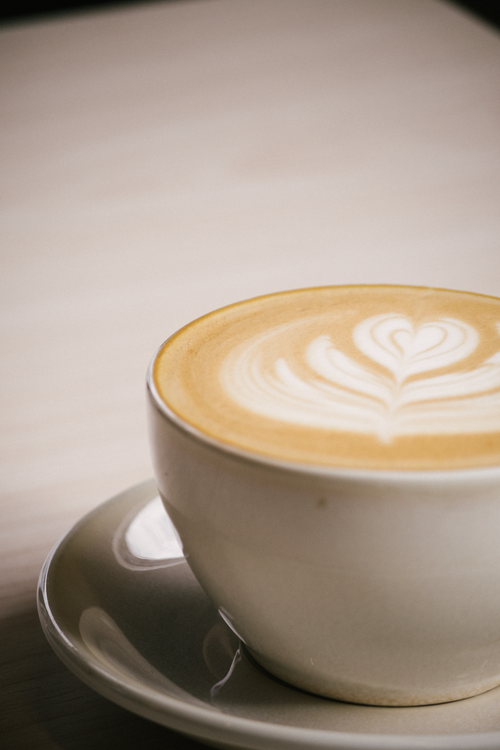 Free A close-up of creamy latte art in a white cup, perfect for coffee enthusiasts. Stock Photo