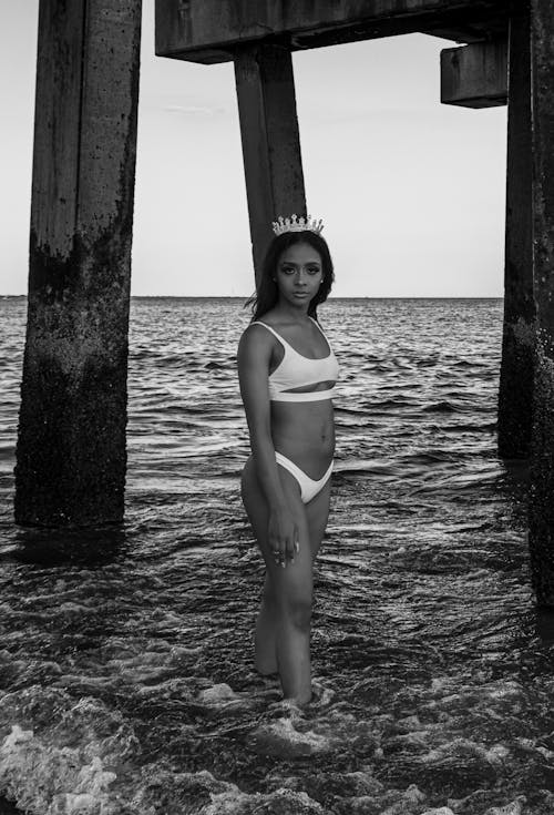 Grayscale Photo of a Woman in Bikini Standing on the Beach