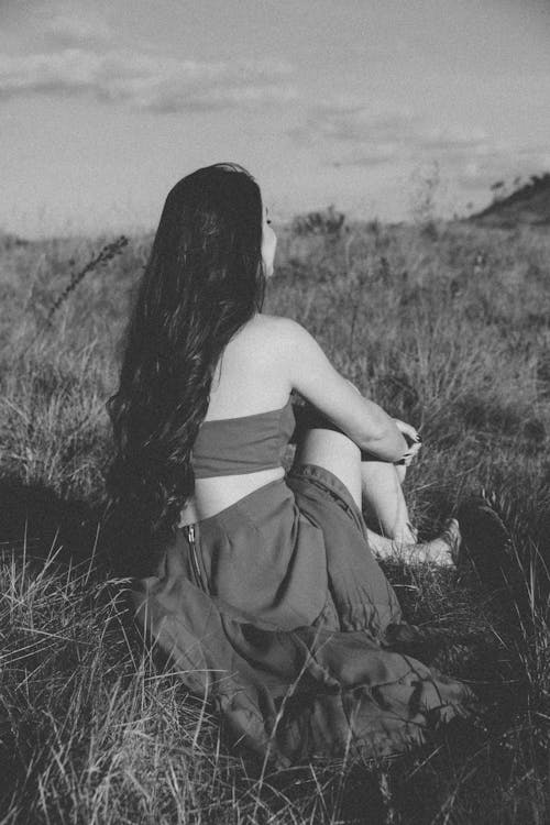 Woman in Tube Dress Sitting on Grass Field