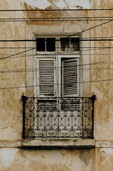 An old balcony with weathered shutters in Aracati, Brazil, showcasing vintage architecture.