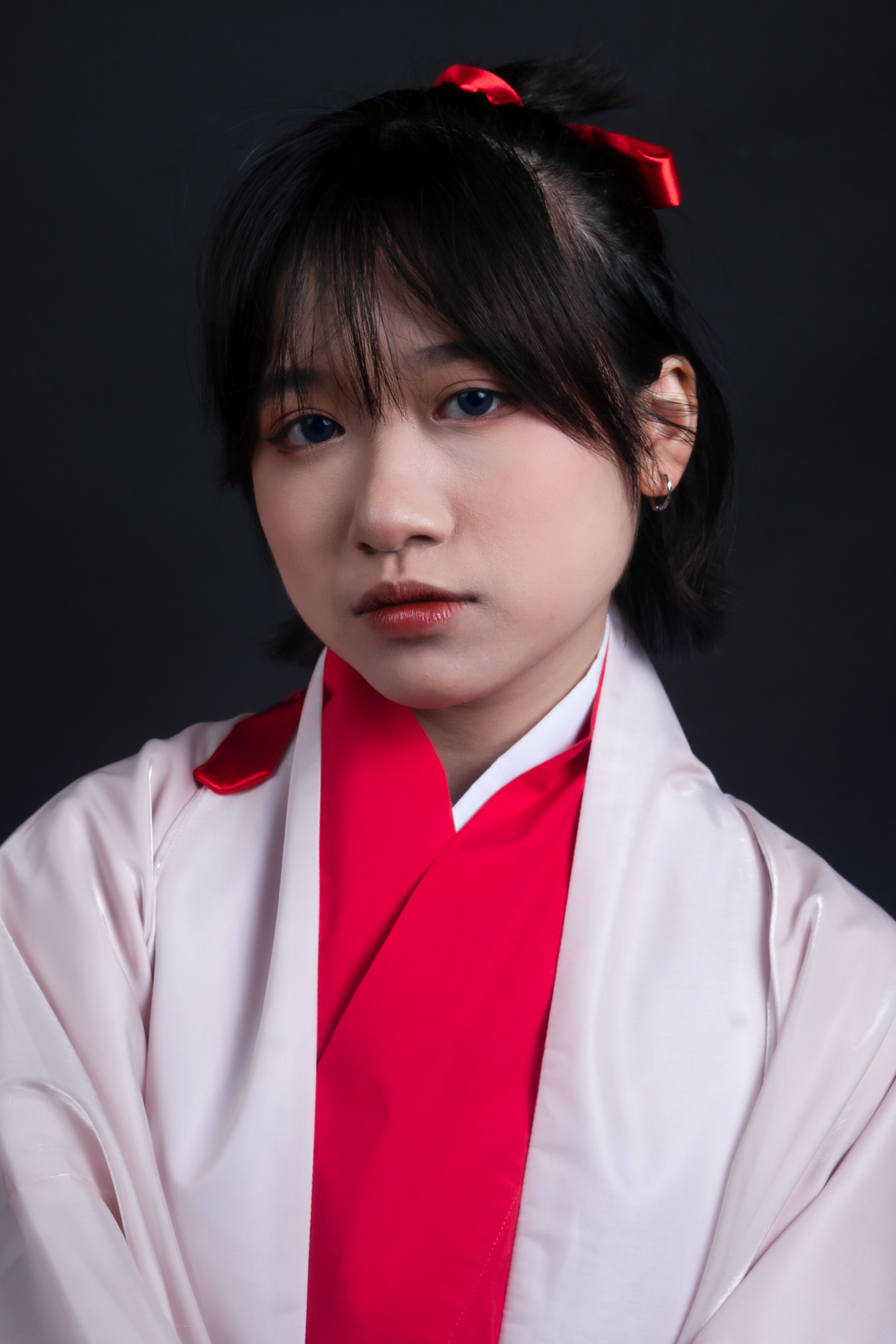 Close-up portrait of an adult woman wearing traditional attire with a dark background.