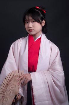 Young woman in traditional kimono holding a fan. Capturing elegance and cultural heritage.