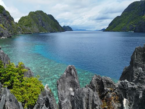 Free Serene view of the clear blue waters and limestone cliffs in El Nido, Philippines. Stock Photo