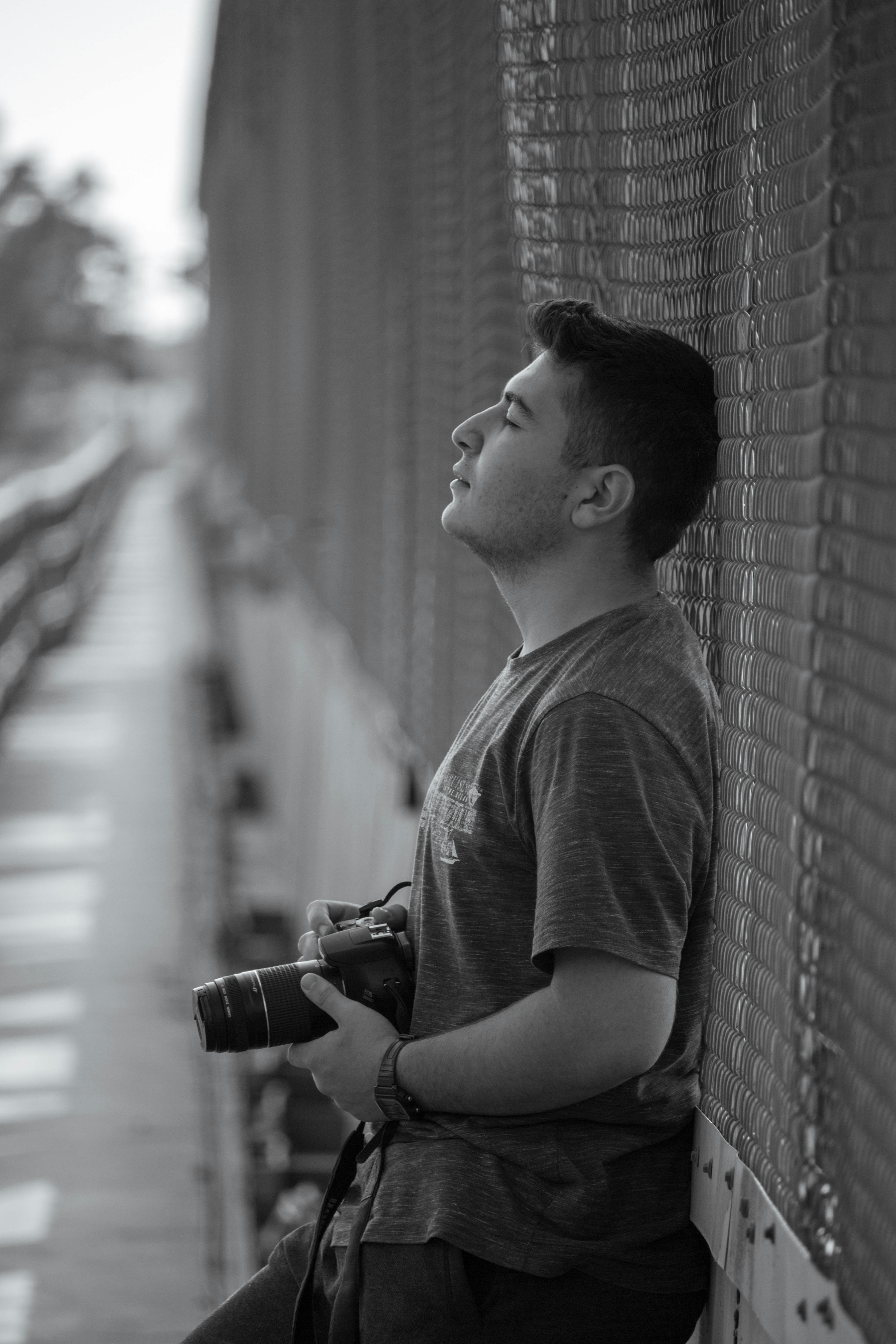 a photographer leaning on a chain link fence