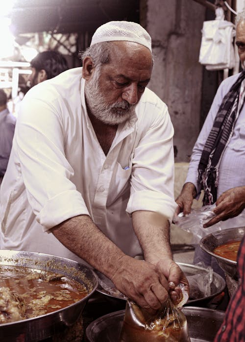 Man in White Button Up Shirt Preparing Food