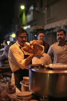 Street vendor preparing food at night, capturing the vibrant urban atmosphere.