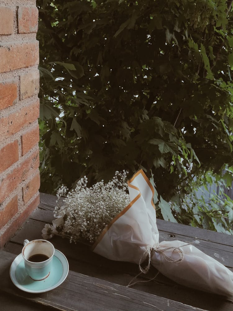 White Coffee Cup With A Bouquet On The Wooden Surface