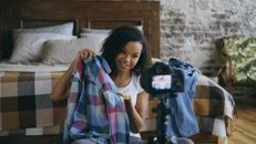 Smiling Girl Showing Clothes on Camera