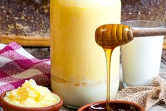 A warm, rustic setup of honey, butter, and milk on a wooden table capturing natural sweetness.