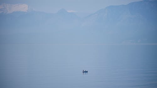 Boat Sailing in the Ocean Near the Mountains 