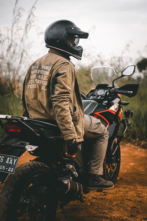 Man in Brown Jacket and Helmet Riding Black Motorcycle