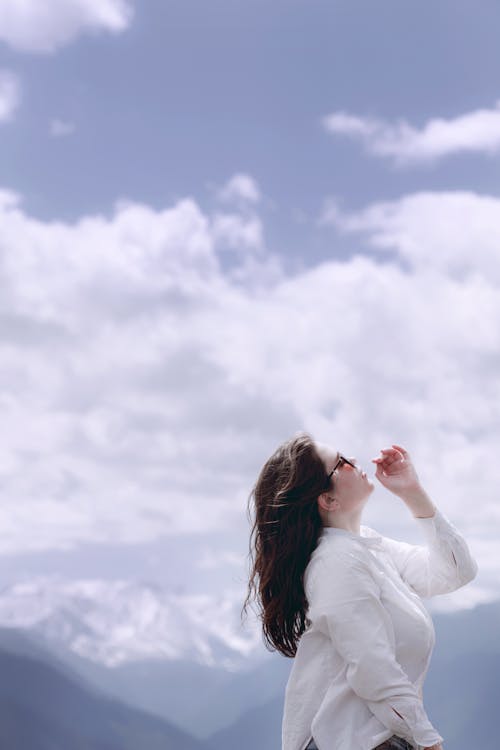 Kostenloses Stock Foto zu bewölkter himmel, frau, hoch schauen