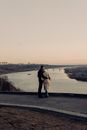 Couple Hugging and Looking at the View of a River 