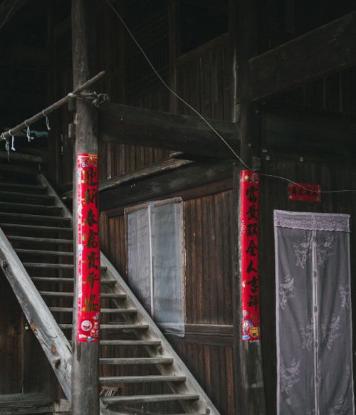 Free Authentic wooden stairway decorated with vibrant red Chinese banners in a traditional building. Stock Photo