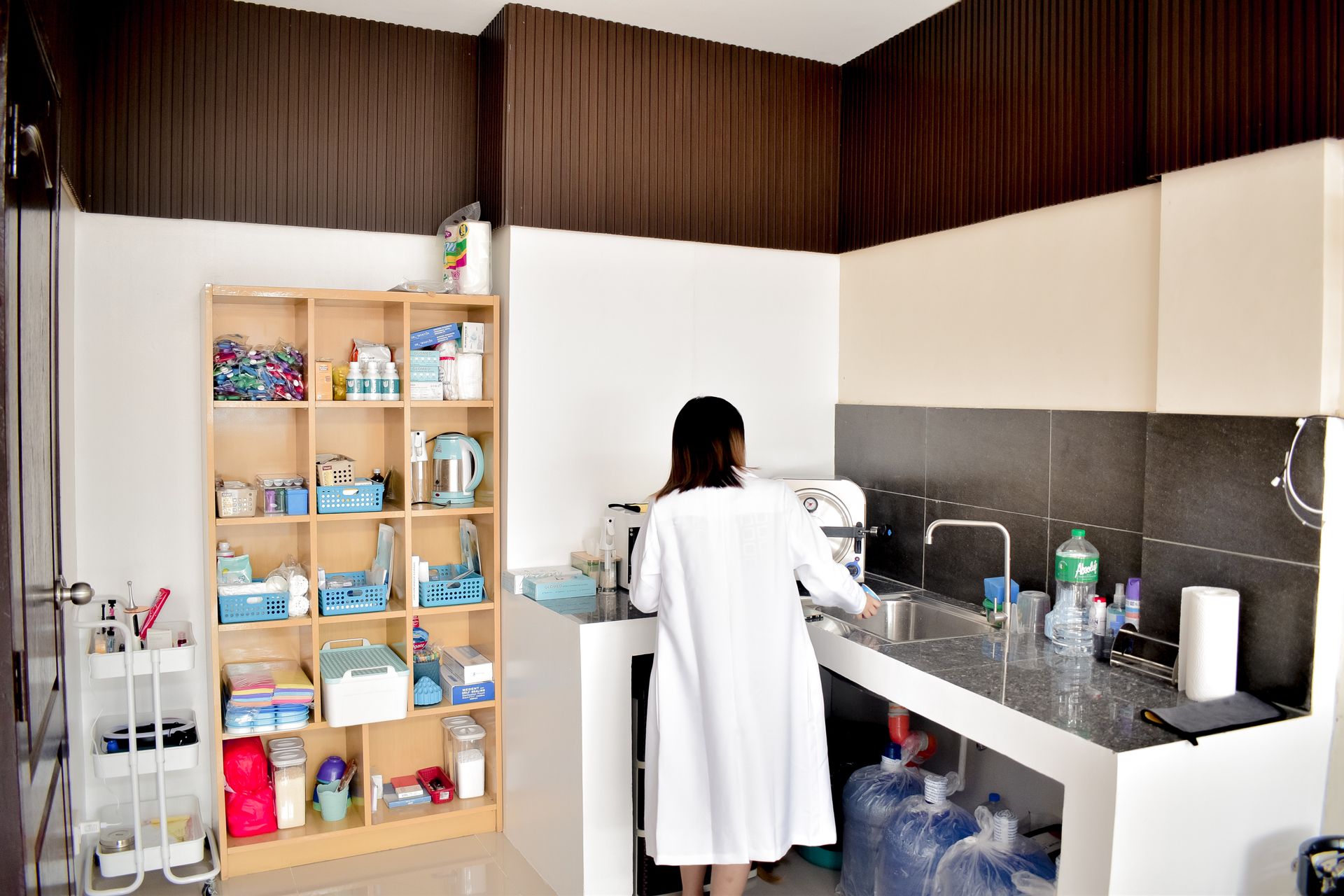 A female technician in a lab coat working in a well-organized laboratory setting.