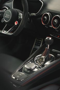 Close-up of a luxury car's sleek interior featuring a stylish watch on the gear console.