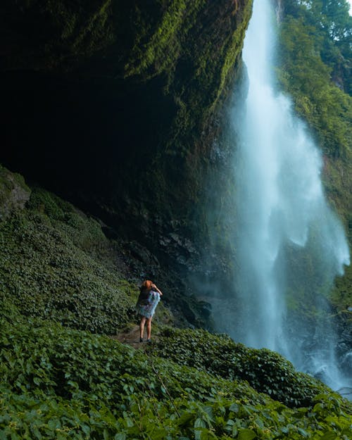 A Woman Standing Close to a Waterfall