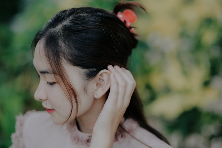 A Woman Tucking Her Hair Behind Her Ear 