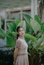 Girl in White Dress Standing Near Green Plant